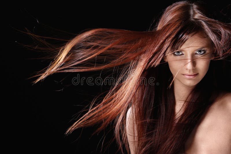 Atraktívna dievča s červenými vlasmi na čiernom pozadí.