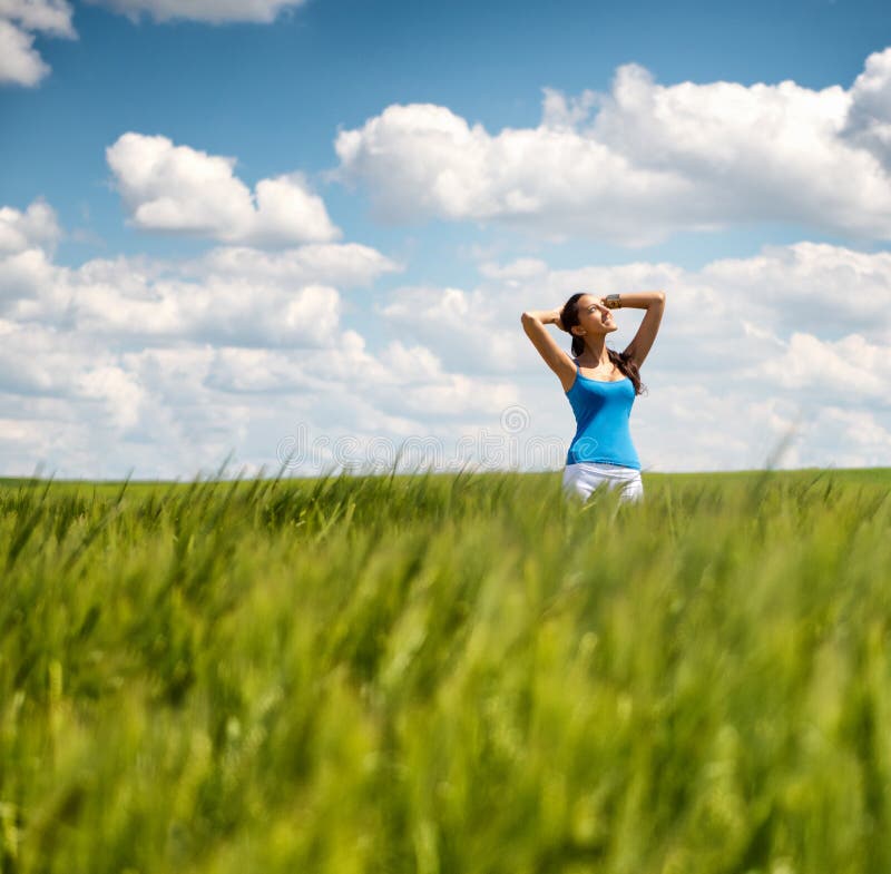 Beautiful girl relaxing in a summer wheat field