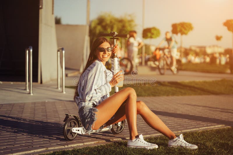 Beautiful Girl with Scooter Posing on Camera. Stock Photo Image of