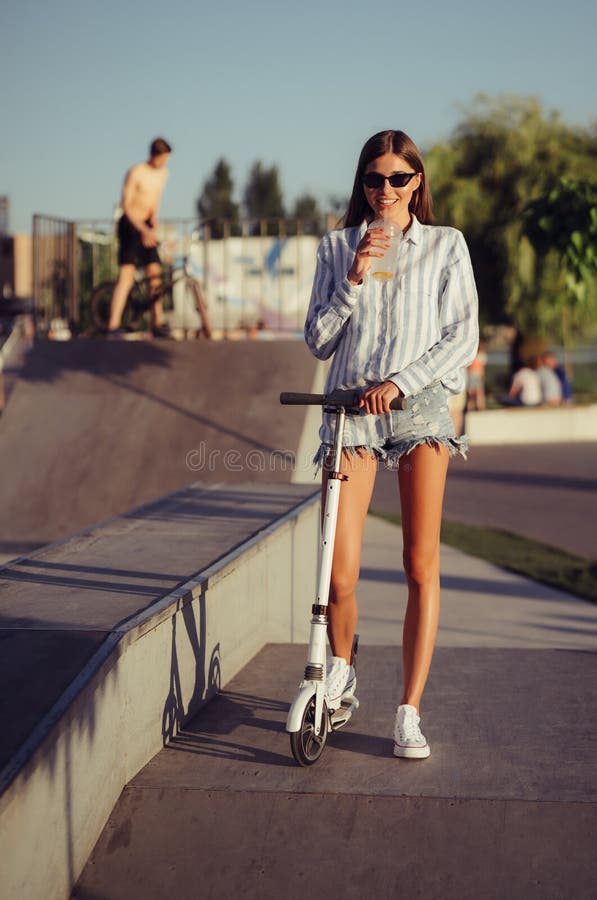 Beautiful Girl with Scooter Posing on Camera. Stock Photo Image of