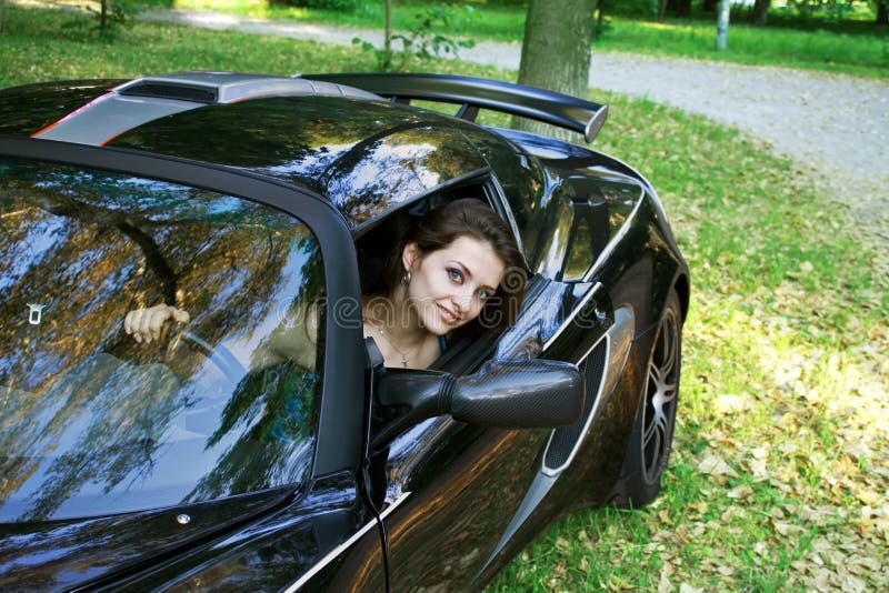 The beautiful girl is sitting in the car