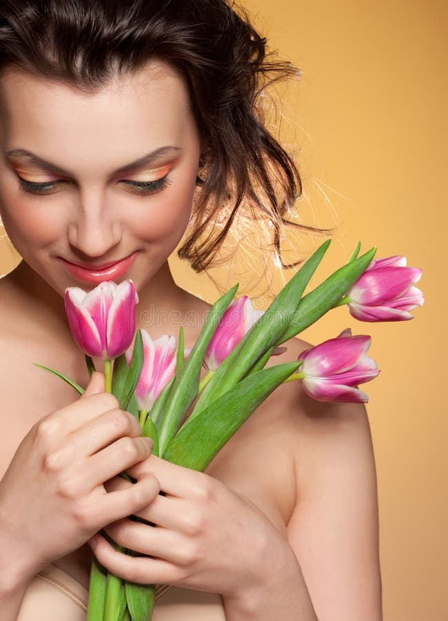 Beautiful girl sniffs a tulip