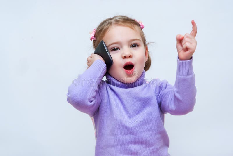 The beautiful girl speaks on the phone and lifted her finger up royalty free stock image The beautiful girl speaks on the phone and lifted her finger up royalty free stock image