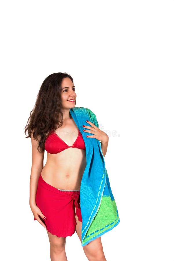 A beautiful girl, wearing red swim suit, holding a beach towel over her shoulder, smiling. A beautiful girl, wearing red swim suit, holding a beach towel over her shoulder, smiling