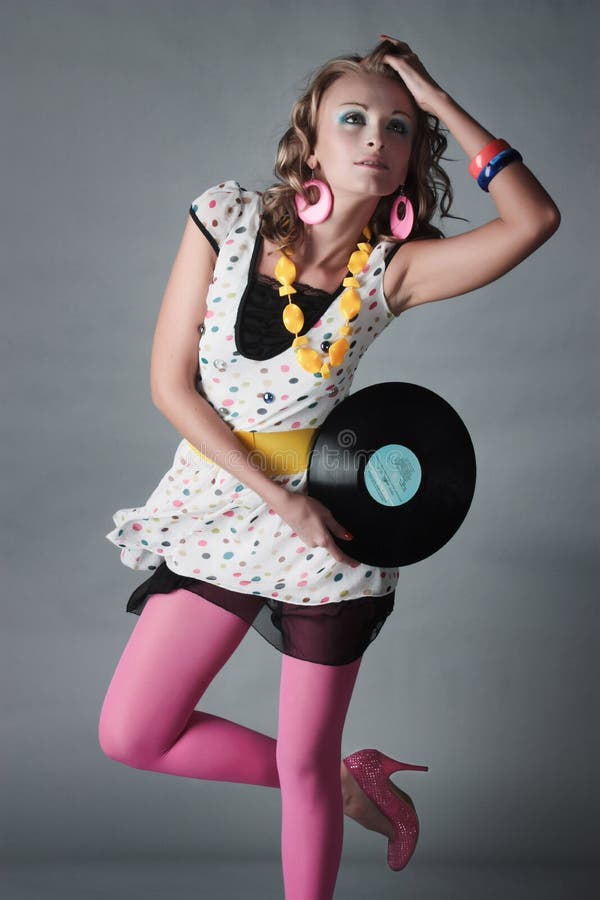 Beautiful girl in trend clothes holding vinyl disc
