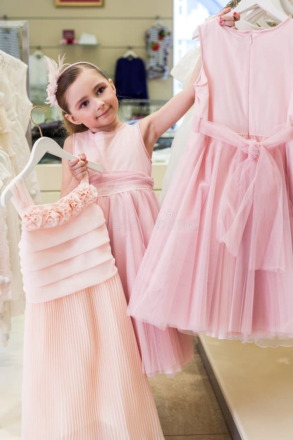 Beautiful Girl Tries on a Pink Dress in a Store Stock Photo - Image of ...