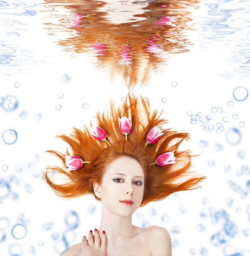 Beautiful girl with tulips in hair underwater.