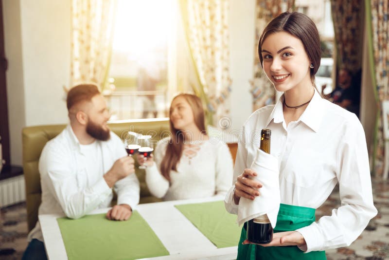 Beautiful girl waiter holds open bottle of wine stock images Beautiful girl waiter holds open bottle of wine stock images