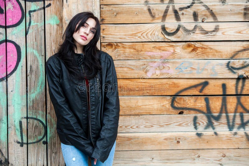 Beautiful girl with wavy hair in black leather jacket. Portrait of cute young business woman outdoor stock image Beautiful girl with wavy hair in black leather jacket. Portrait of cute young business woman outdoor stock image