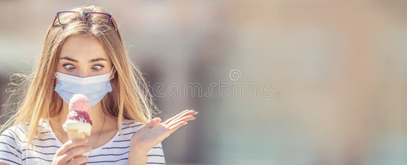 Beautiful girl wearing a face mask looking down at an ice cream in her hand with a cross-eyed look and deperate hand gesture