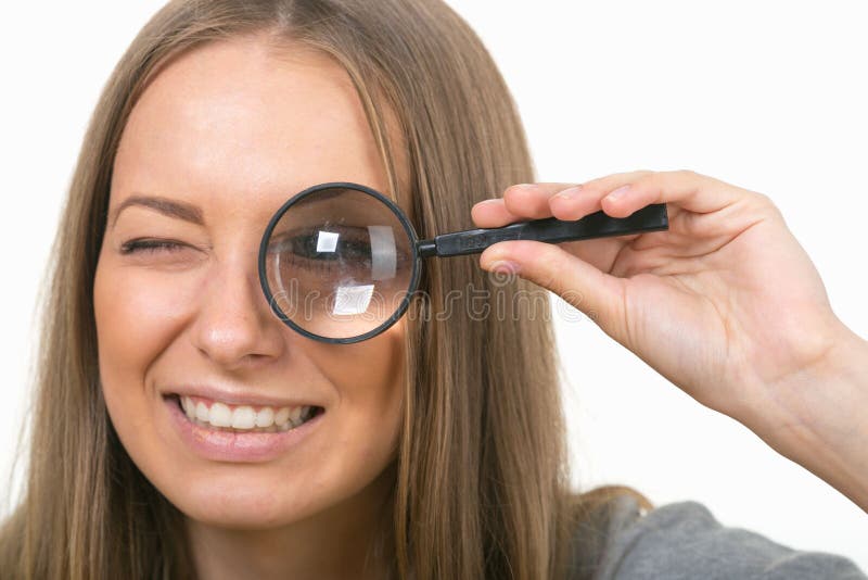 Beautiful Girl on a White Background with a Magnifying Glass Stock