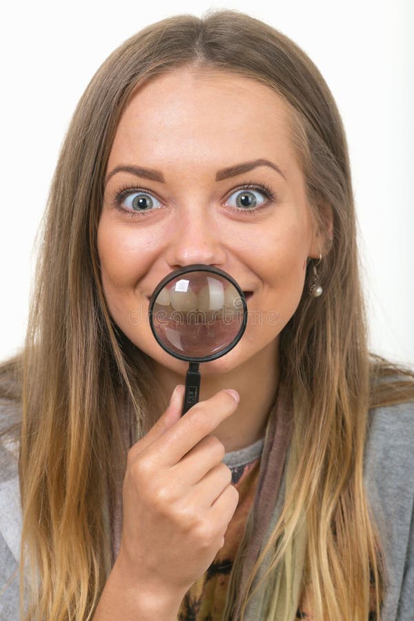 Beautiful Girl on a White Background with a Magnifying Glass Stock