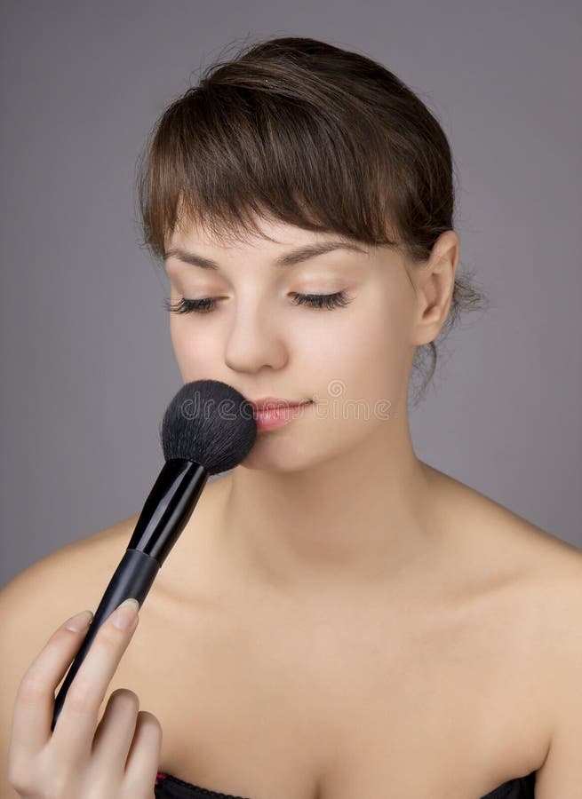 Beautiful girl who does make-up brush