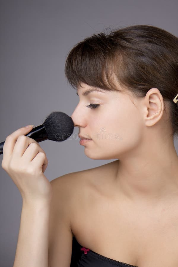 Beautiful girl who does make-up brush