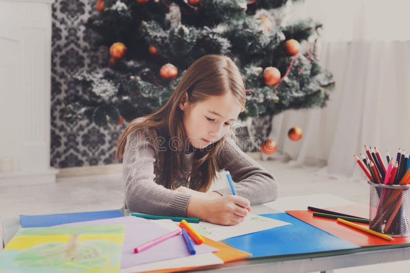 Beautiful girl writing letter to santa, wait for christmas