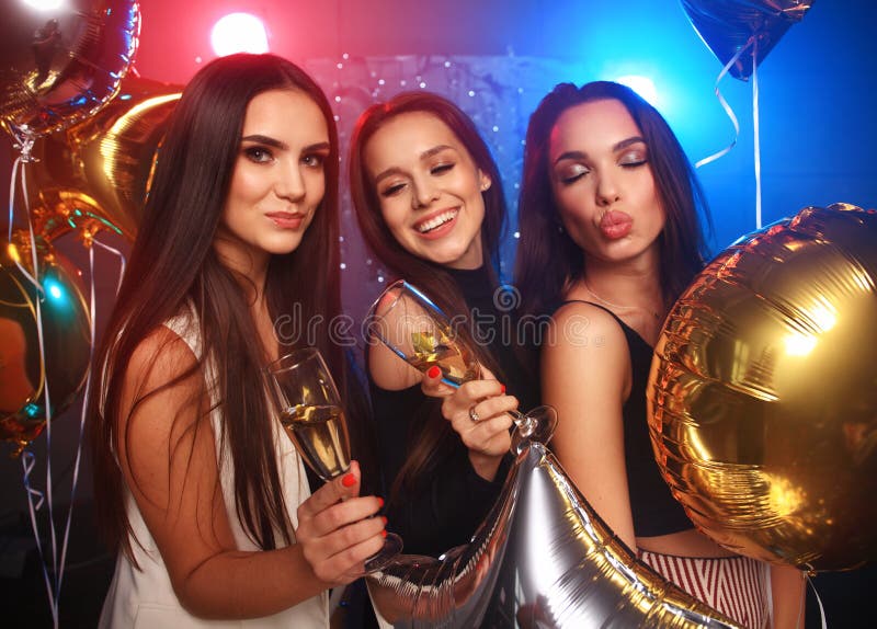 Party, holidays, celebration, nightlife and people concept - smiling friends dancing in club
