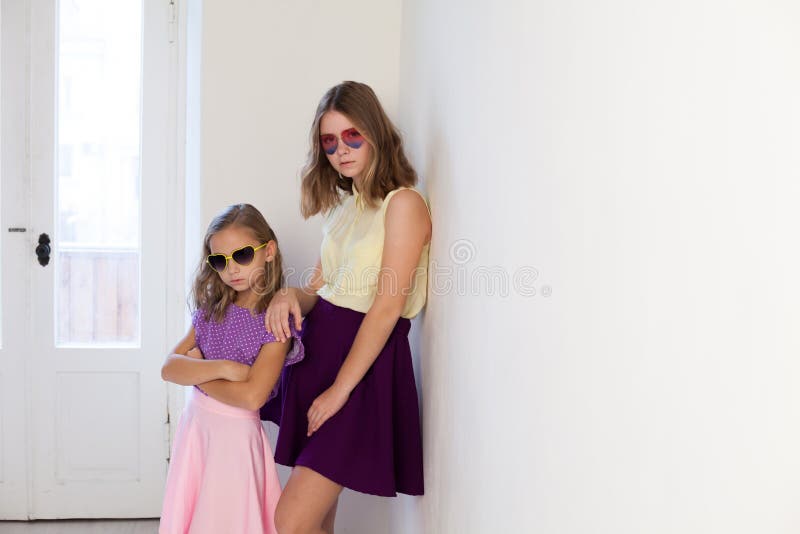 Two beautiful girls sisters in dresses fashionable portrait family