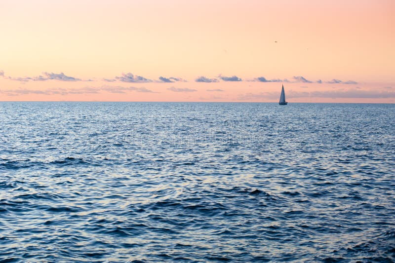 Beautiful gold sunset with a sailboat sailing. Sea. Yacht.