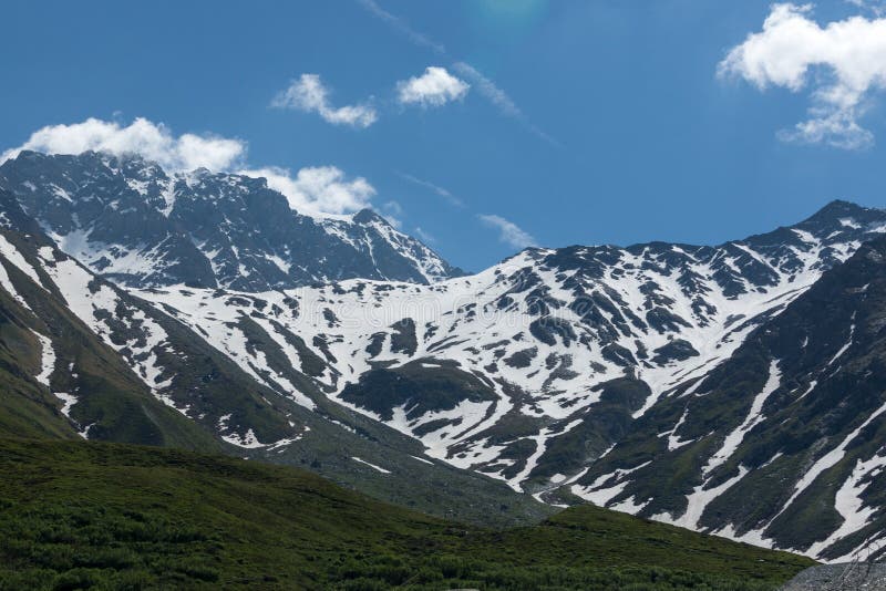 Beautiful Green Valley With Covered Snow Mountain Peaks Stock Photo