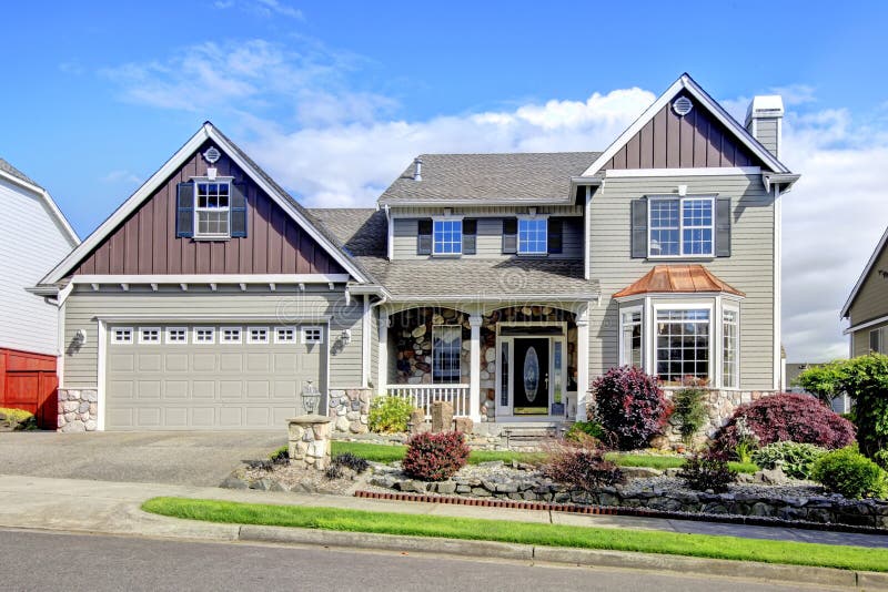 Beautiful grey new classic home exterior with natural stone.