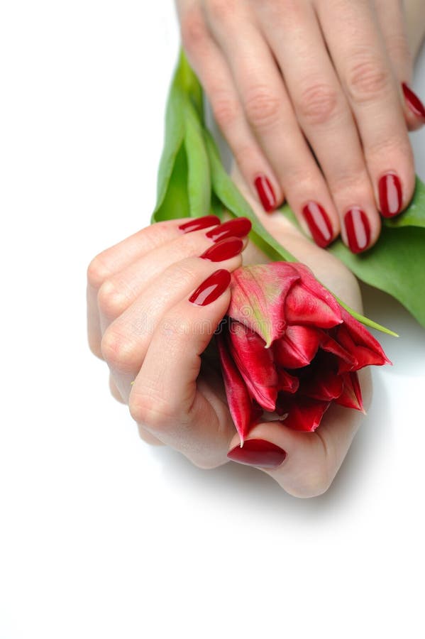 Beautiful hand with red manicure and flowers