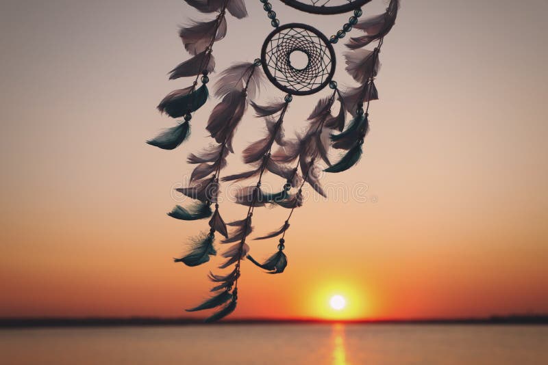 Beautiful handmade dream catcher near river at sunset. Space for text  Photos