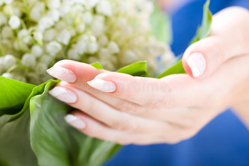 Beautiful hands with bunch of may lily