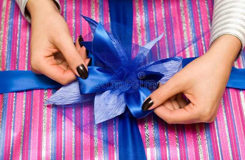 Beautiful hands wrapping giftbox