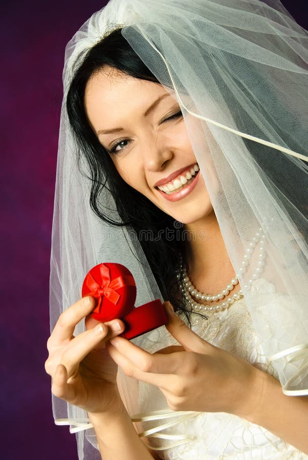 Beautiful happy bride holding a wedding ring