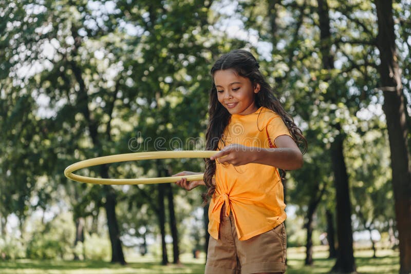 beautiful happy child playing with hula hoop