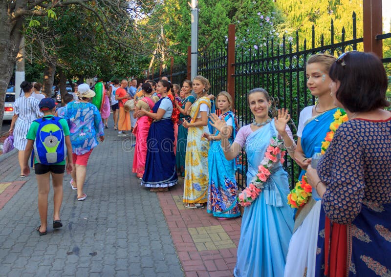 Beautiful and happy women and girls are hare Krishna in bright dresses dancing and singing on the streets of Sochi in the summer stock image Beautiful and happy women and girls are hare Krishna in bright dresses dancing and singing on the streets of Sochi in the summer stock image