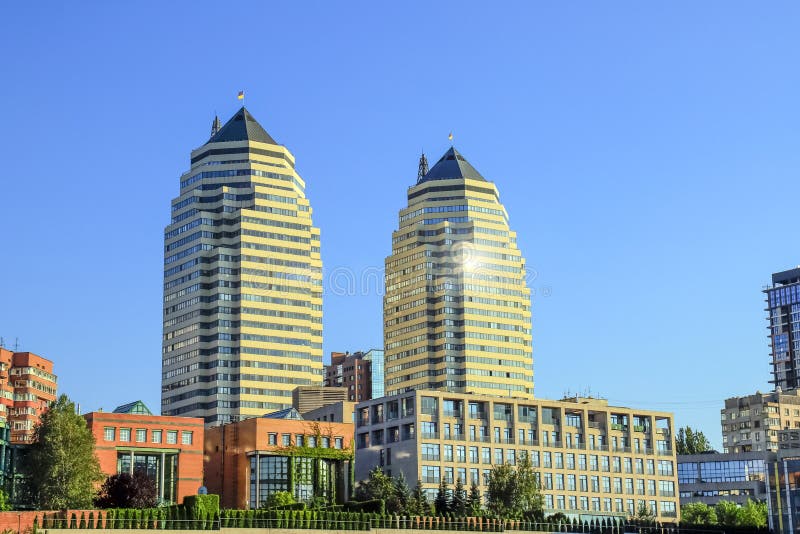 Beautiful high brick skyscrapers, towers and buildings in white and orange with a sun flare. View of the Dnipro city stock image Beautiful high brick skyscrapers, towers and buildings in white and orange with a sun flare. View of the Dnipro city stock image