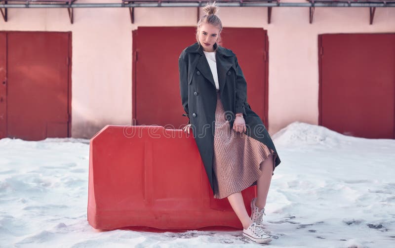 Beautiful hipster blonde woman wearing fashion long coat and dress on the street royalty free stock photography Beautiful hipster blonde woman wearing fashion long coat and dress on the street royalty free stock photography