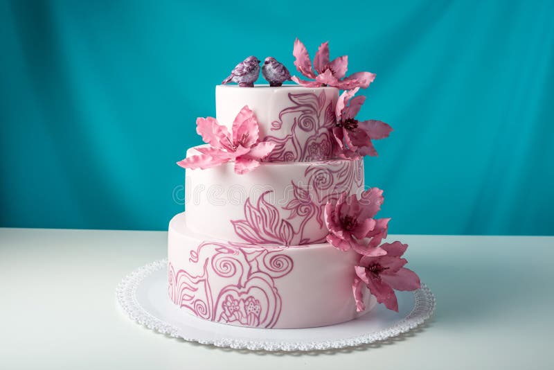 A beautiful home wedding three-tiered cake decorated with pink flowers. Event, celebration.