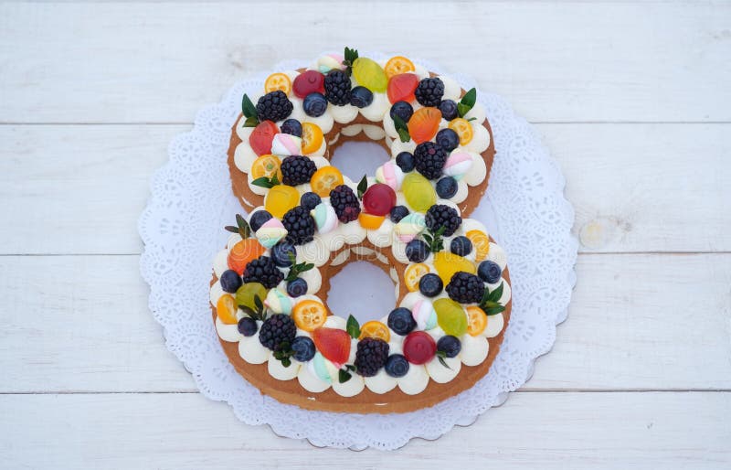 Beautiful homemade cake in the shape of the number eight with natural berries