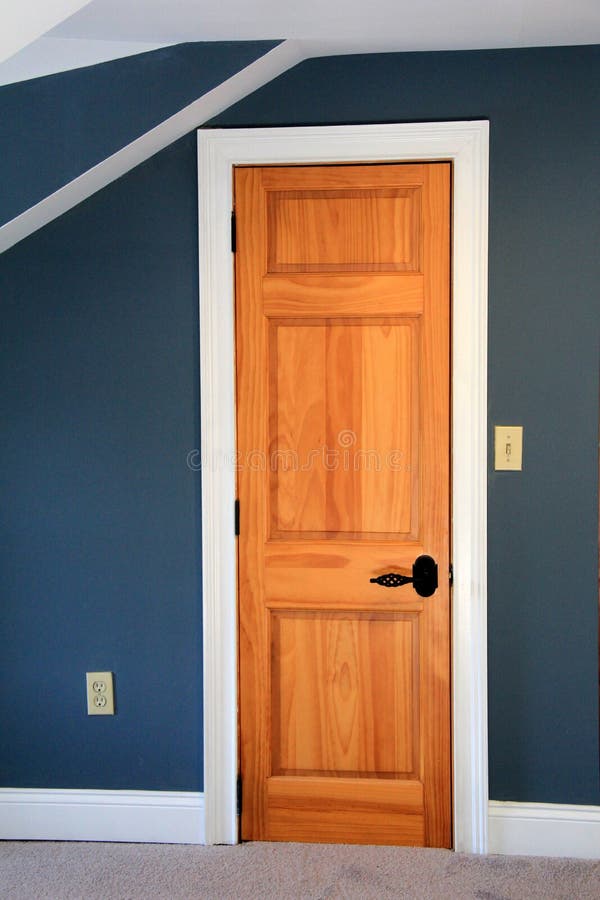 Beautiful image of deep blue painted walls and wood door of bedroom