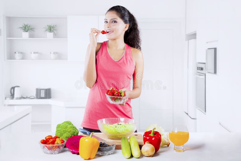 Beautiful Indian Woman tasting strawberry