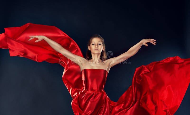 Beautiful inspirational woman dancing in a red silk dress flying