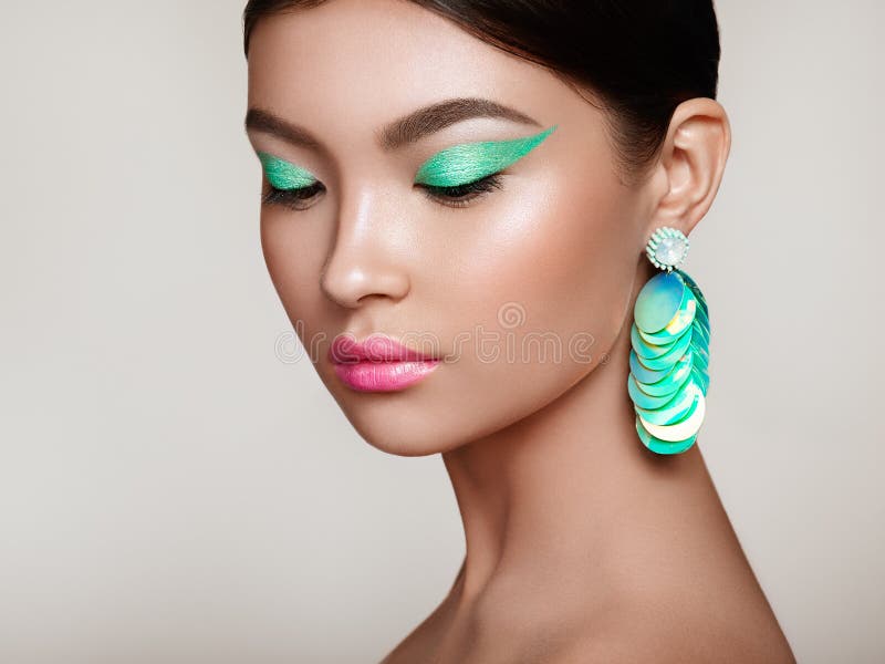 Beautiful Korean Woman with large turquoise earrings royalty free stock photo Beautiful Korean Woman with large turquoise earrings royalty free stock photo