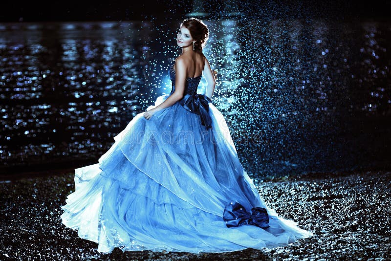 Beautiful lady in blue dress walking near sea