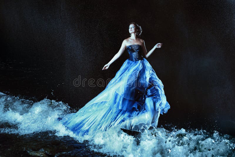 Beautiful lady in blue dress walking near sea