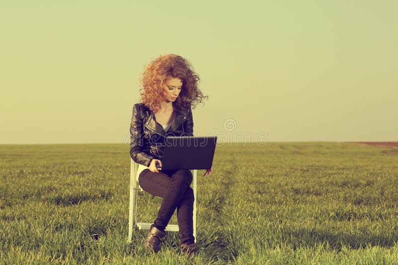 Beautiful lady with her laptop on grass stock photography Beautiful lady with her laptop on grass stock photography