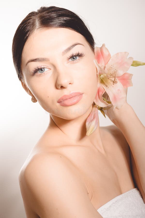 Beautiful lady with lilly flower. Perfect skin.