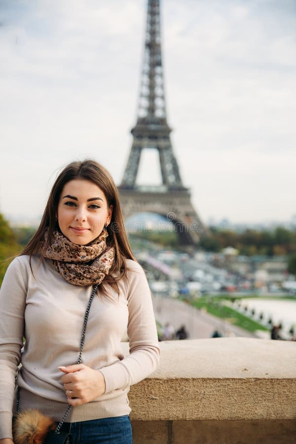 Beautiful Lady Sist On Border Against Of Eiffel Tower. Lady Smile And 