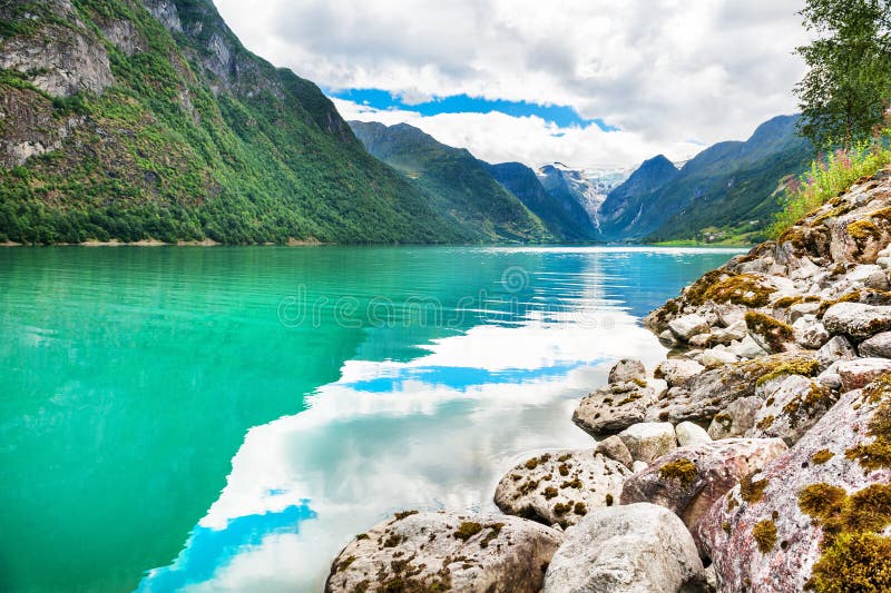 Beautiful lake in the mountains and view of Briksdal glacier in Norway.