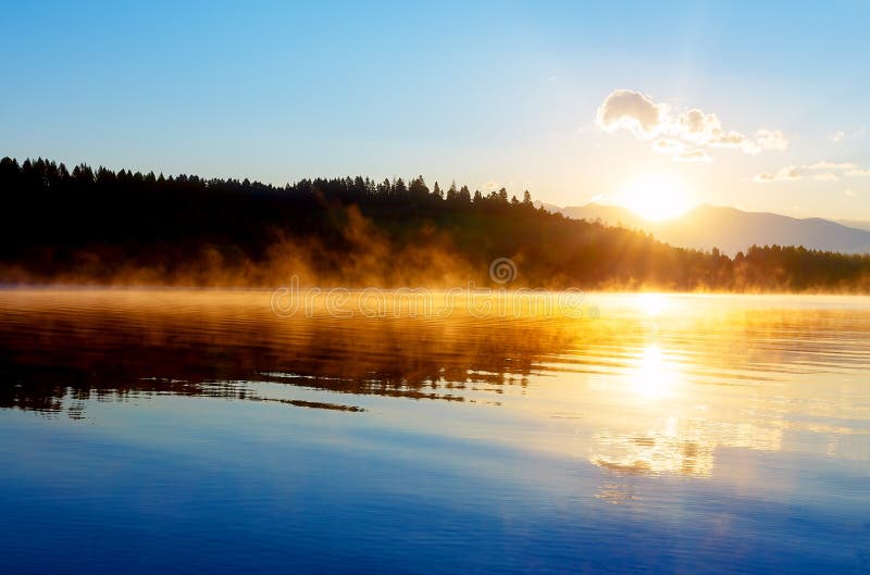 Beautiful landscape with mountains and lake at dawn in golden blue and orange tones. stock images Beautiful landscape with mountains and lake at dawn in golden blue and orange tones. stock images