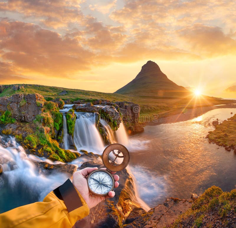 Beautiful landscape with old compass on traveler`s hand.