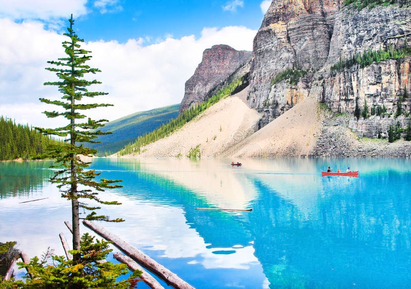 Beautiful landscape with Rocky Mountains and tourists canoeing on azure mountain lake, Alberta, Canada. Beautiful landscape with Rocky Mountains and tourists canoeing on azure mountain lake, Alberta, Canada