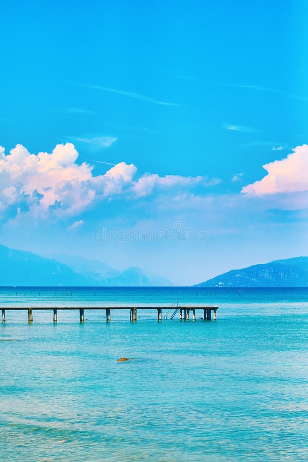 Beautiful landscape view of summer lake Garda in Italy with turquoise water and amazing pink evening clouds royalty free stock image Beautiful landscape view of summer lake Garda in Italy with turquoise water and amazing pink evening clouds royalty free stock image