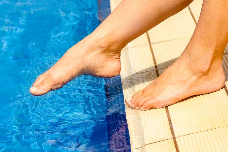 Beautiful legs of a girl near a swimming pool on the sea background